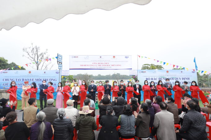 Participants gather on stage to celebrate the launch ceremony for the trash trap on the Red River, Vietnam