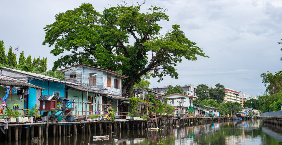 A canal in Bangkok with bits of trash floating on top