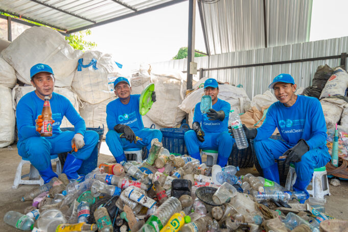 Four workers site around a pile of plastics holding various plastic items